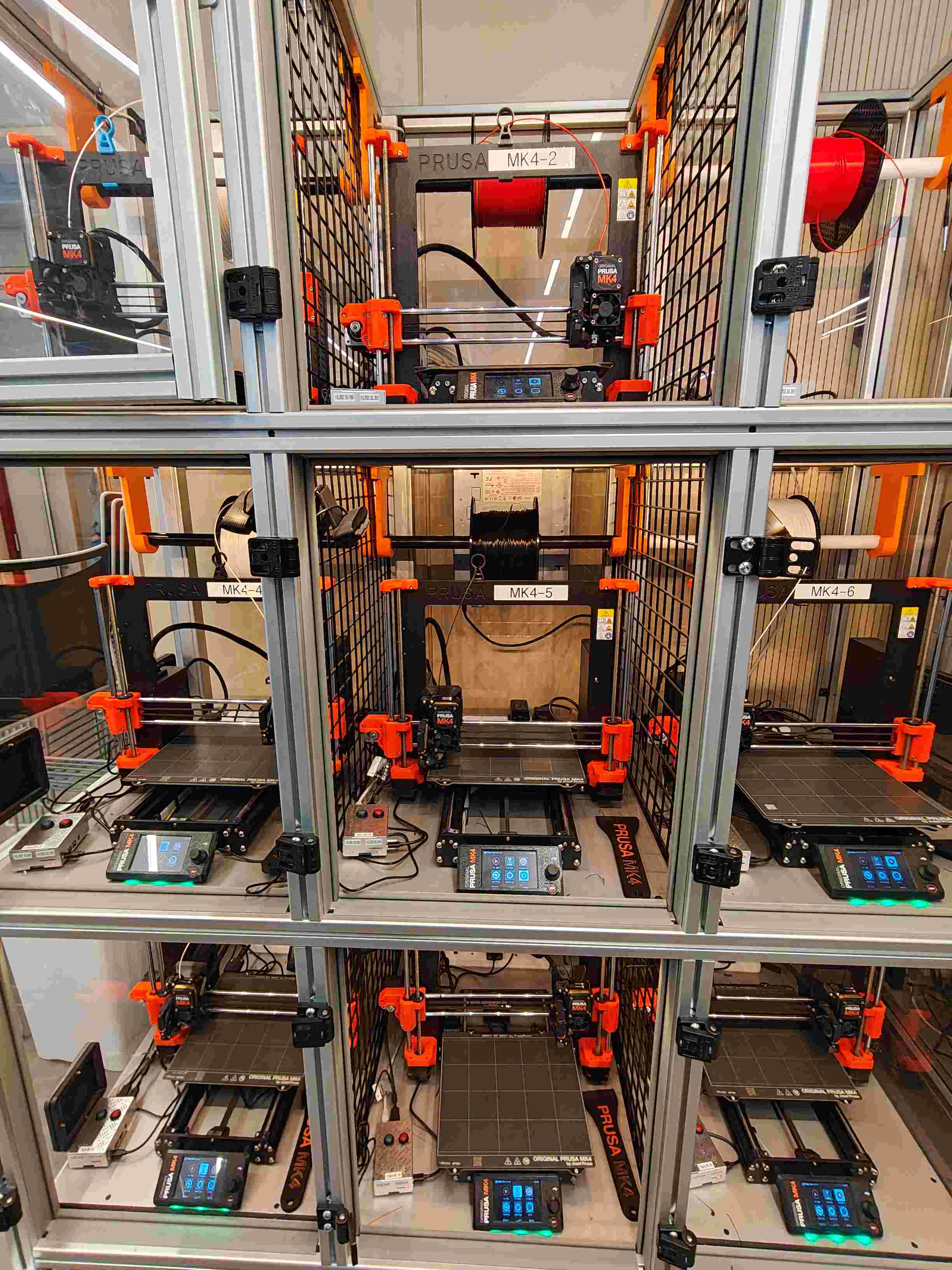 Prusa MK4 print farm rows with sample prints and machine ID tags, set up for an open day walk-through.